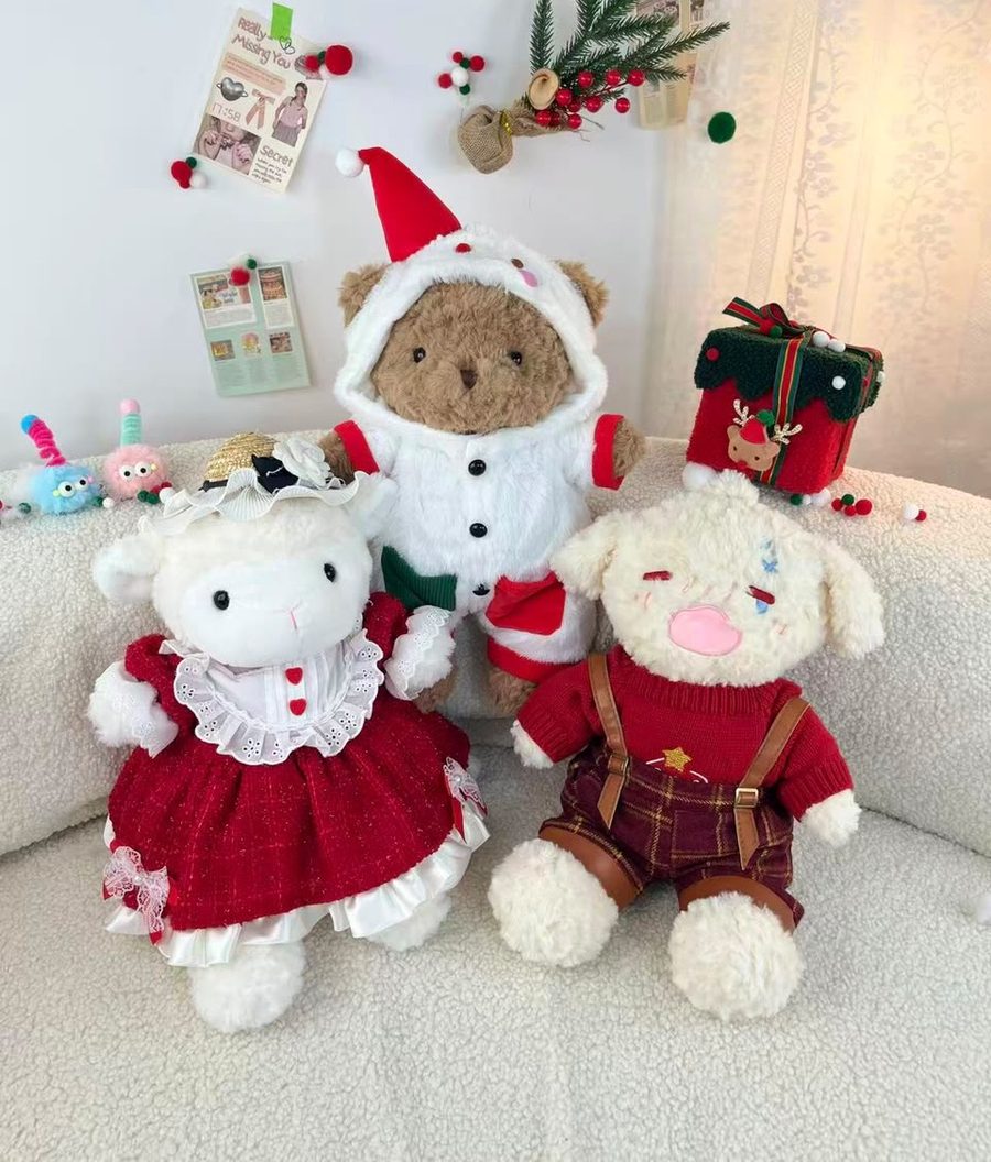 Tres peluches vestidos con atuendos navideños: oveja, oso con gorro de Santa y perro con suéter rojo